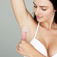 Frau rasiert sich unter dem Arm